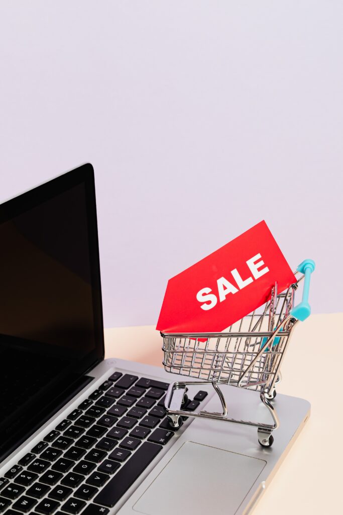 Imagem de um carinho de compras online em uma mesa com um notebook, representando a praticidade e facilidade de comprar pela internet